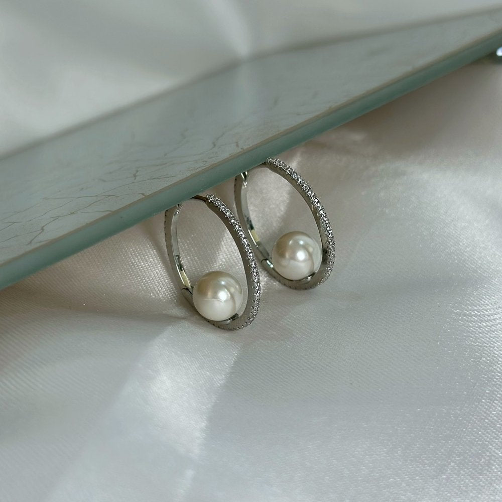 Brinco ródio branco média argola delicada com uma fileira cravejada de zircônias e perola no centro