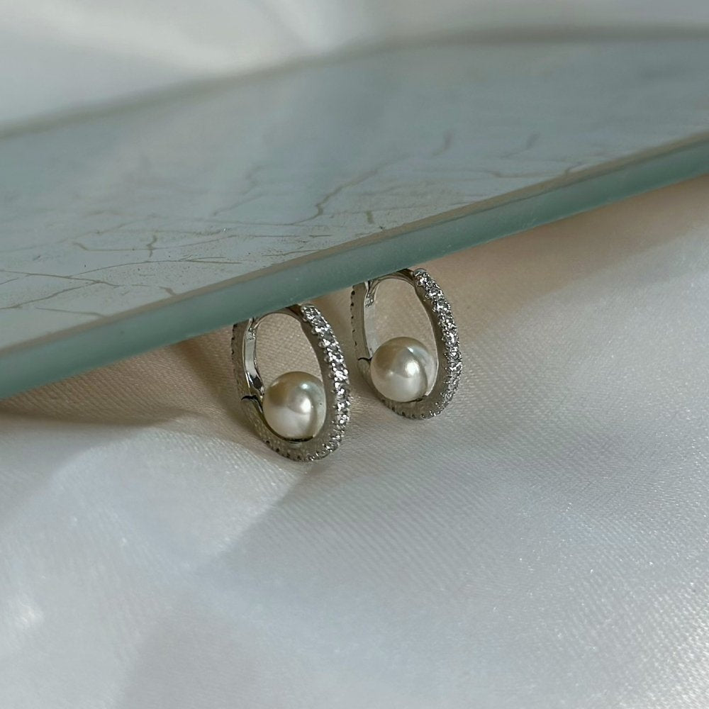 Brinco ródio branco pequena argola delicada com uma fileira cravejada de zircônias e perola no centro